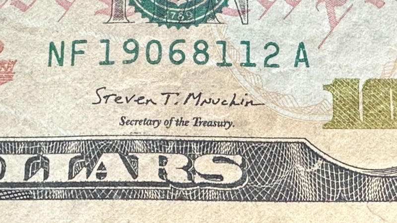 Photo of Steven Mnuchin's signature on a 10 dollar bill.