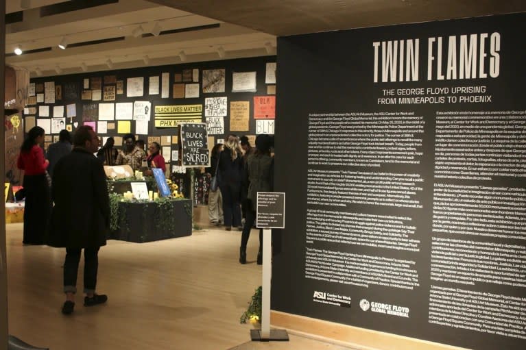 Visitors walk through a new exhibit, “Twin Flames: The George Floyd Uprising from Minneapolis to Phoenix,” at Arizona State University Art Museum, in Tempe, Arizona on Friday, Feb. 2, 2024. (AP Photo/Cheyanne Mumphrey)