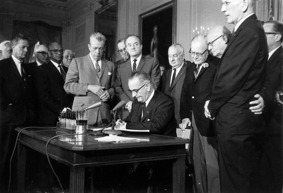 This July 2, 1964 photo shows President Lyndon Baines Johnson signing the Civil Rights Act in the East Room of the White House. Standing, from left, are Sen. Everett Dirksen, R-Ill.; Rep. Clarence Brown, R-Ohio; Sen. Hubert Humphrey, D-Minn.; Rep. Charles Halleck, R-Ind.; Rep. William McCullough, R-Ohio; and Rep. Emanuel Celler, D-N.Y. The Civil Rights Act of 1964 is considered one of the most celebrated legislative achievements in U.S. history. This law made it illegal to discriminate on the basis of race, color, religion, sex, or national origin and barred unequal application of voter registration requirements.