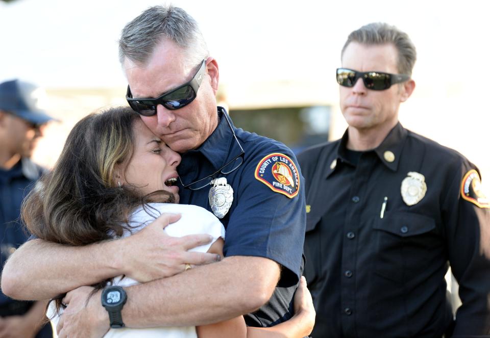 John Denton, a Los Angeles County firefighter paramedic, comforts Nancy Iskander, the mother of Mark and Jacob Iskander, during a 2022 vigil in Westlake Village.
