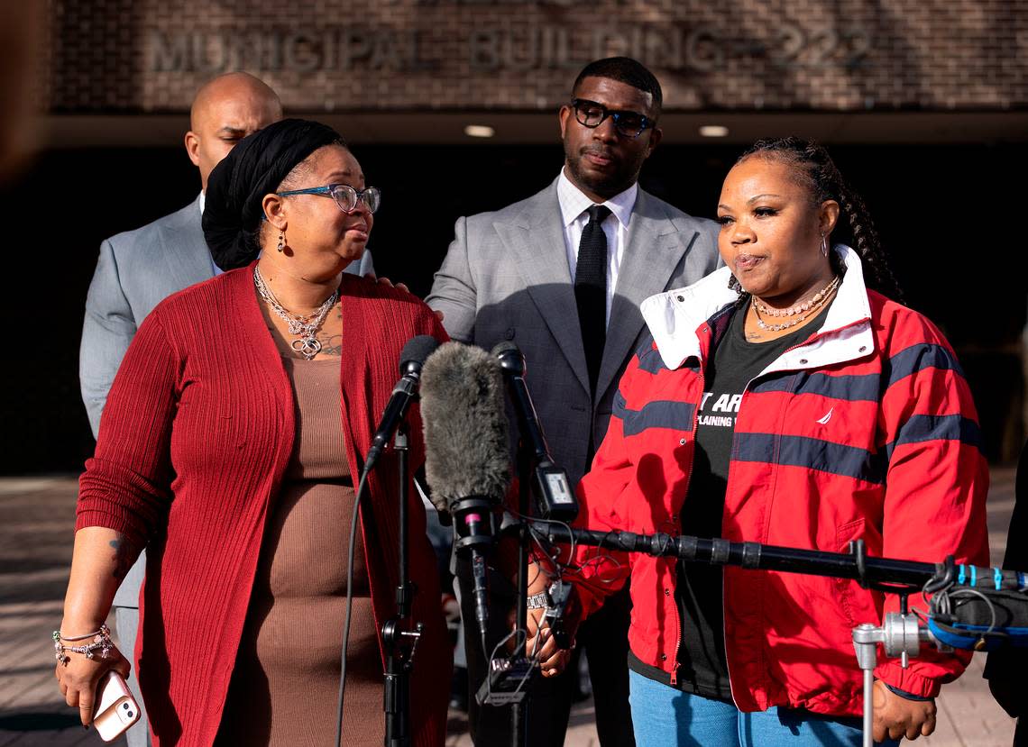 Yolanda Irving and Kenya Walton, mothers whose homes were raided in 2020 when Raleigh police officers served a no-knock warrant on the wrong home, hold hands as they speak during a press conference on Monday, Jan. 30, 2023, in Raleigh, N.C.