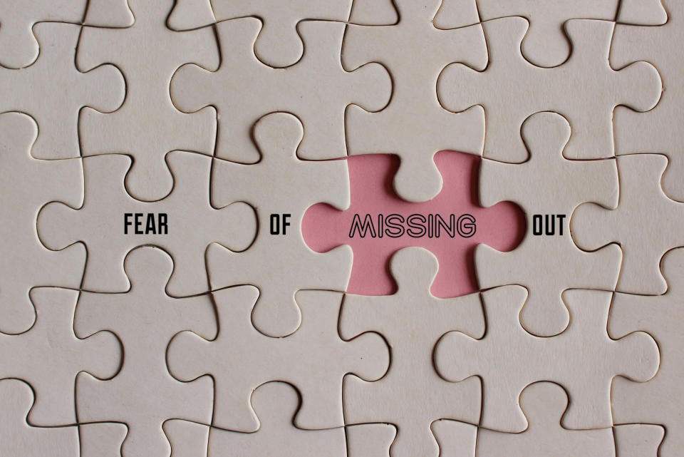 Top view image of puzzle with text FEAR OF MISSING OUT or FOMO.  Technology and medical concept