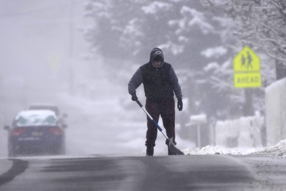 A man clears his driveway of snow from an overnight storm in Provo, Utah on December 13, 2022. (Photo by GEORGE FREY/AFP via Getty Images)