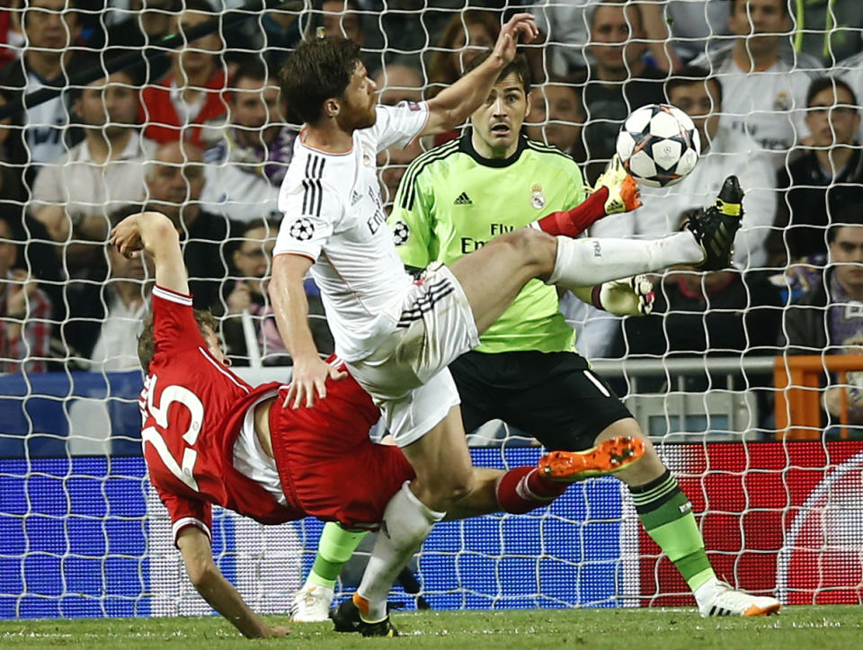 Bayern's Thomas Mueller fights for the ball with Real's Xabi Alonso during a first leg semifinal Champions League soccer match between Real Madrid and Bayern Munich at the Santiago Bernabeu stadium in Madrid, Spain, Wednesday, April 23, 2014. (AP Photo/Andres Kudacki)