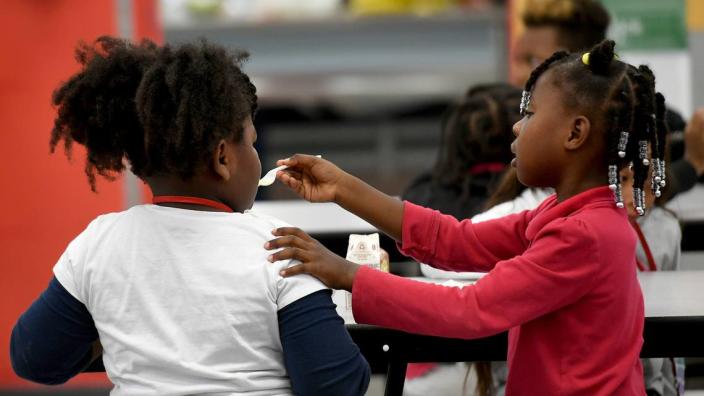 Two students of Manatee Elementary School eat their lunch in the cafeteria. The school is a Community school, with a medical center, food pantry, and other supportive services for the students and their families.