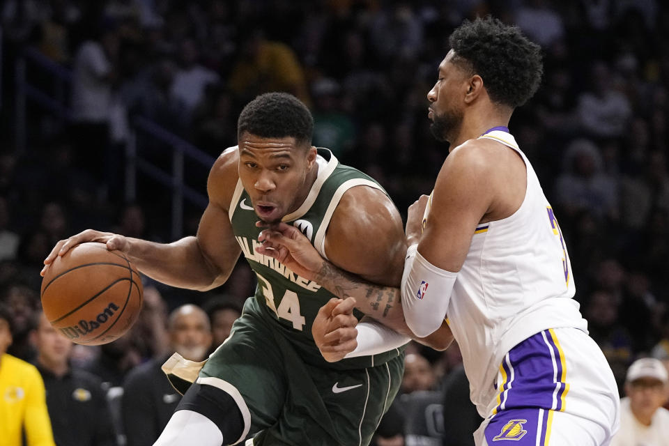 Milwaukee Bucks forward Giannis Antetokounmpo, left, tries to drive past Los Angeles Lakers forward Christian Wood during the first half of an NBA preseason basketball game Sunday, Oct. 15, 2023, in Los Angeles. (AP Photo/Mark J. Terrill)