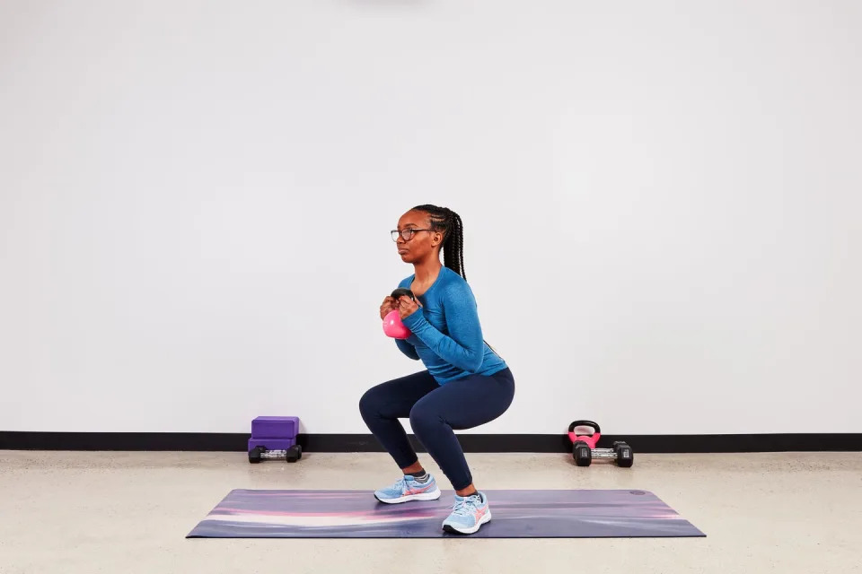 monique lebrun performing a kettlebell squat as part of the transverse abdominis set of exercises