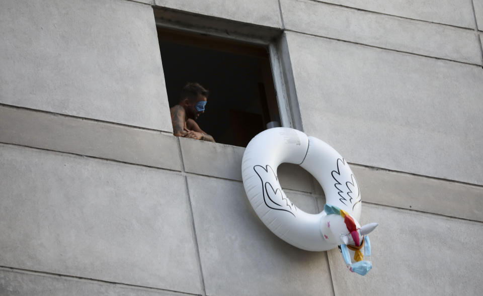 Un hombre que regresó del extranjero se asoma por la ventana desde un hotel mientras está en cuarentena impuesta por el gobierno en Buenos Aires, Argentina, el miércoles 1 de abril de 2020. (AP Foto/Natacha Pisarenko)
