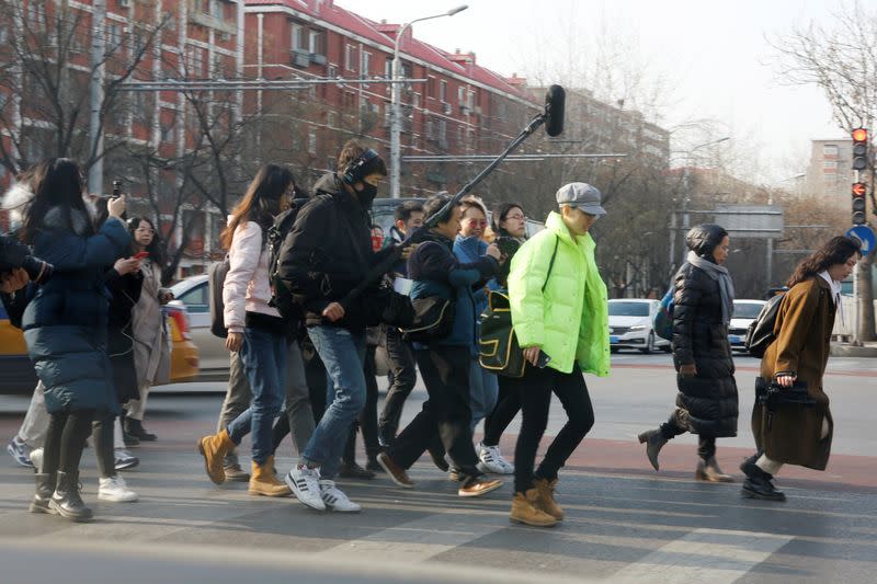 Teresa Xu is surrounded by journalists as she crosses a road near Chaoyang People's Court after a court hearing in Beijing