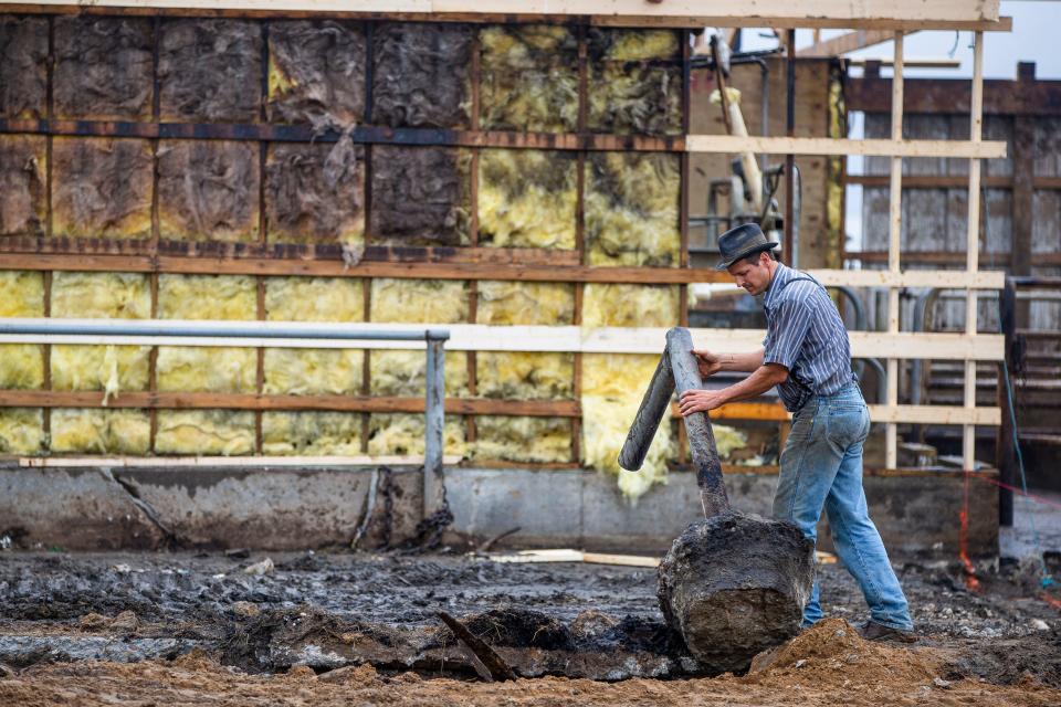 Dan Imhoff, front, surveys damage to his barn from a fire as he gets help rebuilding Tuesday, Sept. 21, 2021 near Wakarusa. 