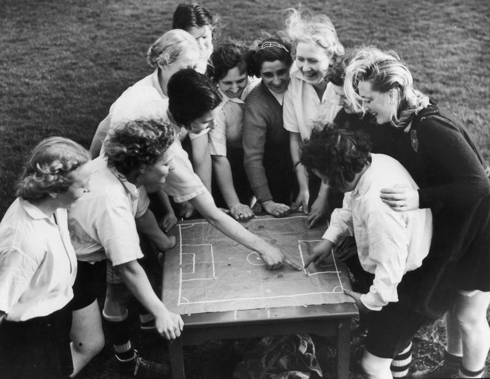 1939: Members of the Preston Ladies Football Club listen to their captain, Miss Parr, as she discusses tactics with the aid of a cloth pitch diagram (Getty Images)
