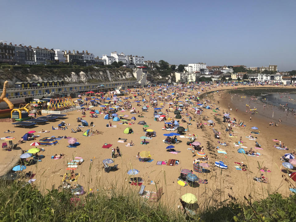 People flock to Broadstairs beach in Kent, England, Thursday July 25, 2019. Paris and London and many parts of Europe are bracing for record temperatures as the second heat wave this summer bakes the continent. The Paris area could be as hot as 42 C (108 F) Thursday as a result of hot, dry air coming from northern Africa that's trapped between cold stormy systems. (Wesley Johnson/PA via AP)