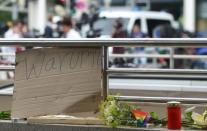 A sign reading "Why?" next to candles and flowers at an underground station near the Olympia-Einkaufszentrum shopping centre on July 23, 2016, one day after the attack in Munich