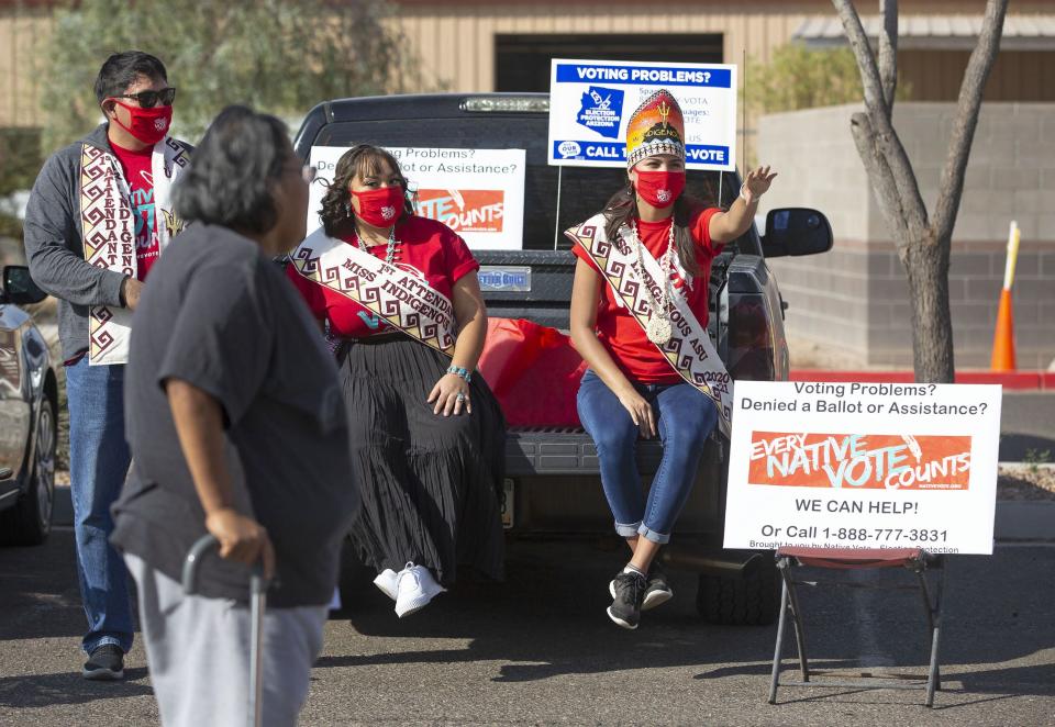 Native Vote volunteers Randy Long (from left),  Jolene Fernandez and Lourdes Pereira direct voter Danita Moffett to the polls at Casa Blanca Veterans Memorial Building in Bapchule on Nov. 3, 2020.