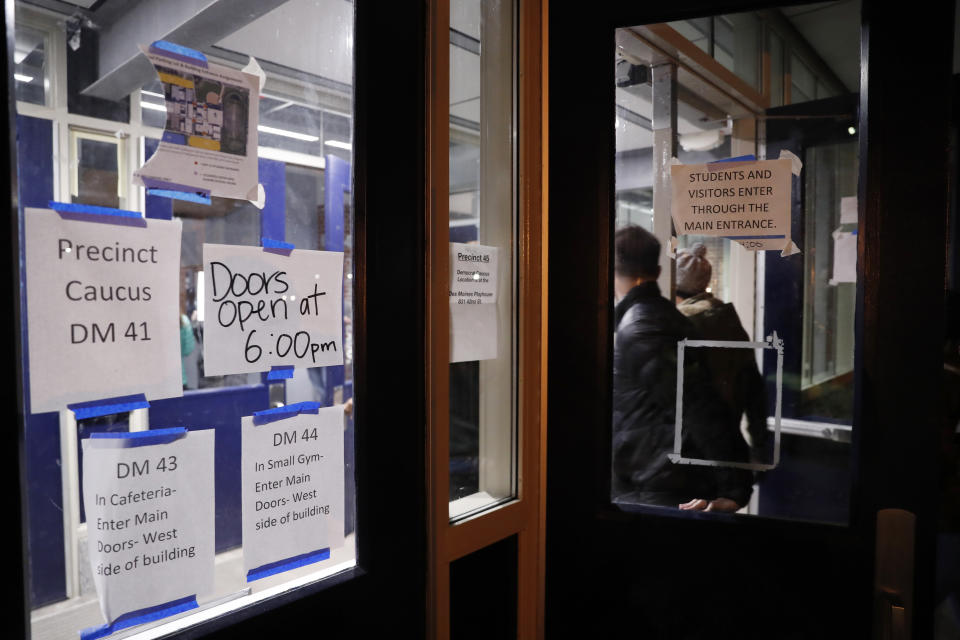 Caucus goers arrive at a caucus at Roosevelt Hight School, Monday, Feb. 3, 2020, in Des Moines, Iowa. (AP Photo/Andrew Harnik)