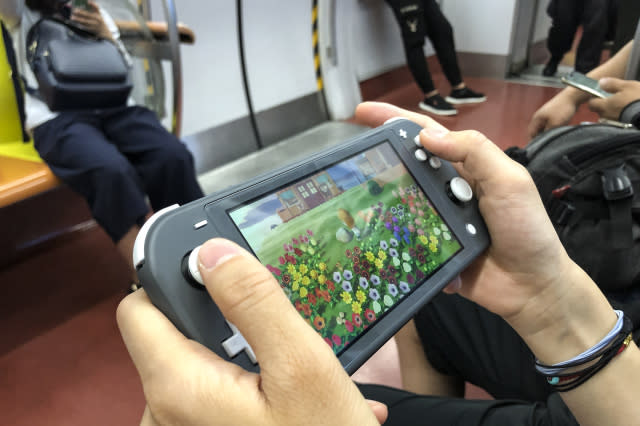 BEIJING, CHINA - JUNE 14: A passenger uses a Nintendo Switch to play video game 'Animal Crossing: New Horizons' on a subway train of Beijing Subway Line 1 on June 14, 2020 in Beijing, China. (Photo by VCG/VCG via Getty Images)