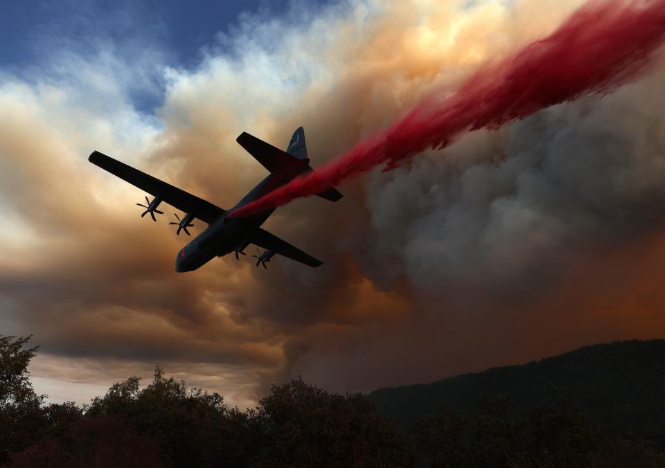 A C-130 aircraft equipped with Modular Airborne Fire Fighting Systems (MAFFS) drops retardant ahead of the LNU Lightning Complex Fire on Aug. 20 in Healdsburg, Calif.