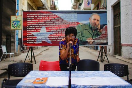 A member of the local electoral commission tests a microphone in front of an image of late Cuban president Fidel Castro on a street where nominations for candidates for municipal assemblies are about to take place, in Havana, Cuba, September 4, 2017. Picture taken on September 4, 2017. REUTERS/Alexandre Meneghini