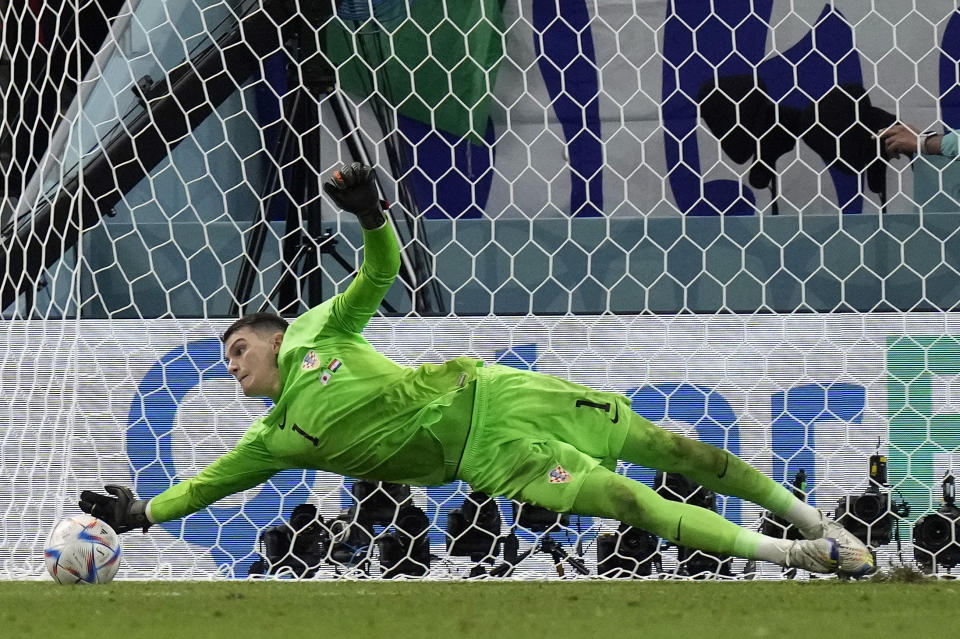 Croatia's goalkeeper Dominik Livakovic saves a penalty kick by Japan's Kaoru Mitoma during the World Cup round of 16 soccer match between Japan and Croatia at the Al Janoub Stadium in Al Wakrah, Qatar, Monday, Dec. 5, 2022. (AP Photo/Eugene Hoshiko)