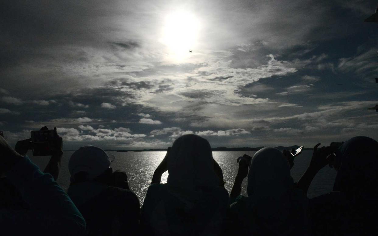 Passengers gather to watch the total solar eclipse onboard the Indonesian cruise ship KM Kelud near the island of Belitung in Indonesia