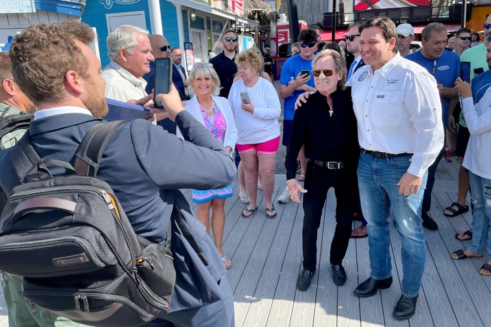 Gov. Ron DeSantis poses for photos Thursday morning on the docks at A.J.'s Seafood & Oyster Bar in Destin, where he announced an extension of the Gulf red snapper fishing season.