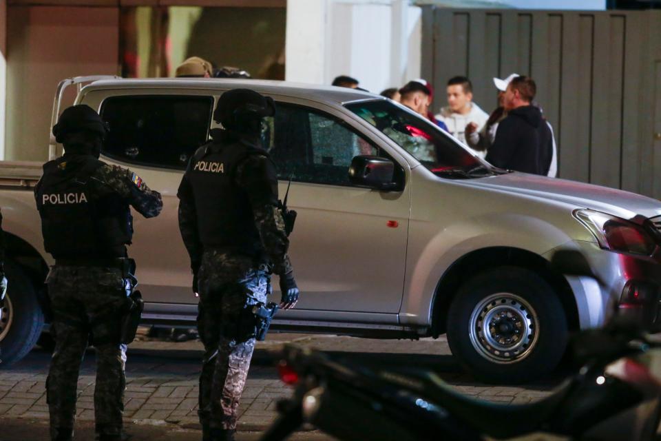 Police guard a vehicle parked outside the clinic where presidential candidate Fernando Villavicencio was taken after he was shot and killed after a campaign rally in Quito, Ecuador.