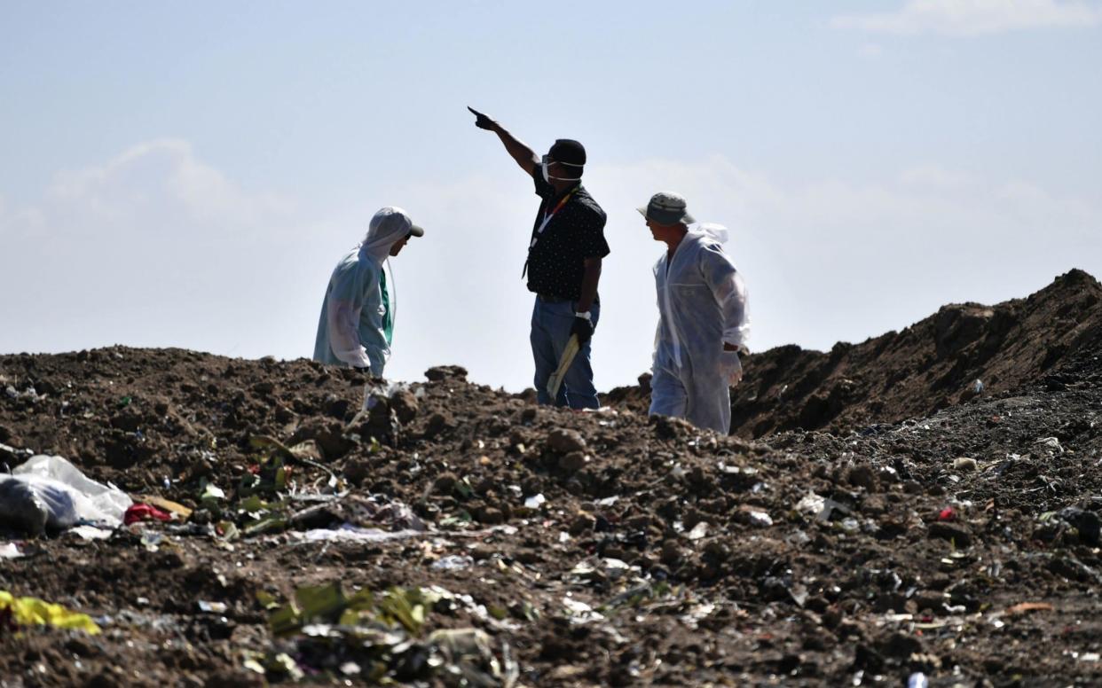 Investigators inspect the crash site of the Ethiopian Airlines plane, which went down on March 10 - AFP