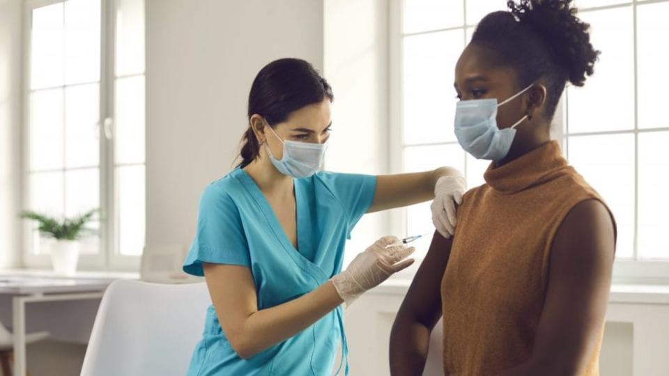 Black woman getting modern flu or Covid-19 vaccine at doctor's office