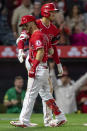 Los Angeles Angels' Andrew Velazquez, left, gets congratulations from Shohei Ohtani after Velazquez hit a two-run home run against the Oakland Athletics during the seventh inning of a baseball game in Anaheim, Calif., Saturday, May 21, 2022. (AP Photo/Alex Gallardo)