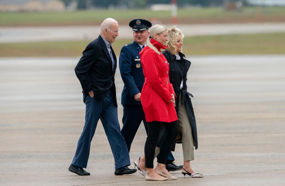 President Joe Biden and first lady Jill Biden, escorted by Col. Matthew Jones, Commander of the 89th Airlift Wing and his wife Christie Jones walk form Marine One to board Air Force One for a trip to Florida to visit areas impacted by Hurricane Ian, Wednesday, Oct. 5, 2022, at Andrews Air Force Base, Md. (AP Photo/Gemunu Amarasinghe)