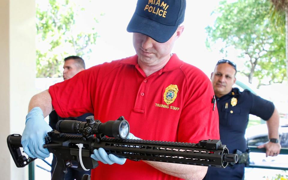 A City of Miami Police instructor secures an AR-15 rifle during a City of Miami gun buy-back event in 2018 - RHONA WISE/AFP via Getty Images