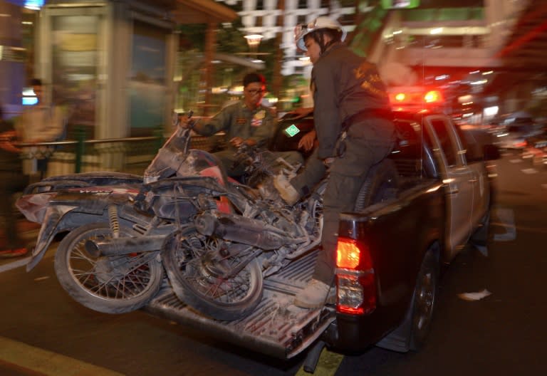 Rescue workers transport damaged motorcycles from the scene of a bomb blast outside a religious shrine in central Bangkok late on August 17, 2015