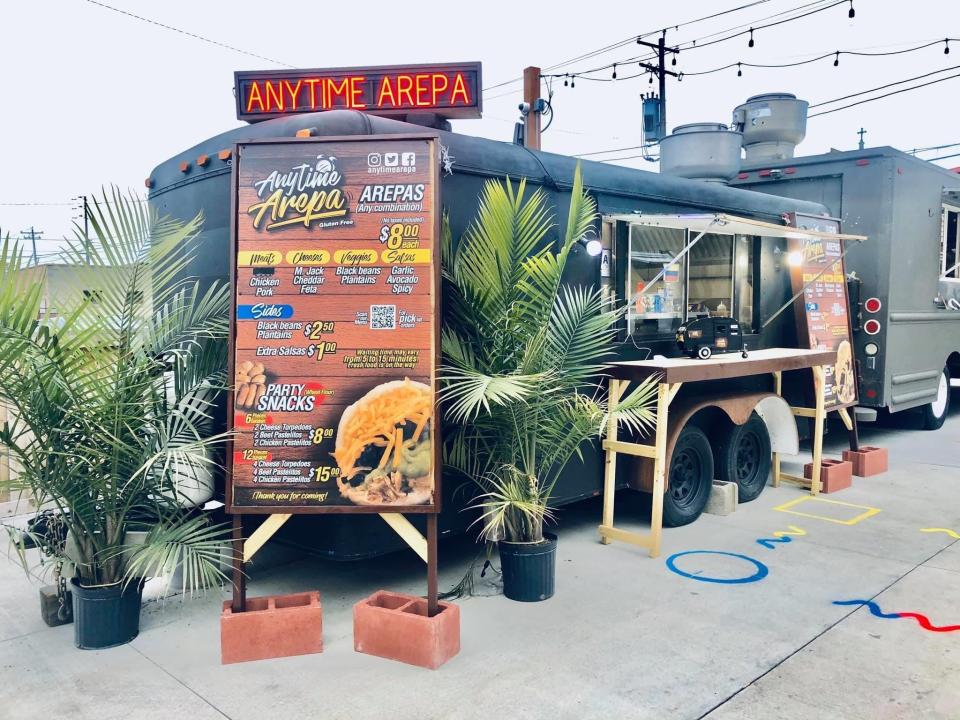 A neon sign lights the way to the Anytime Arepa food truck, parked at Zocalo Food Truck Park at 636 S. Sixth St.