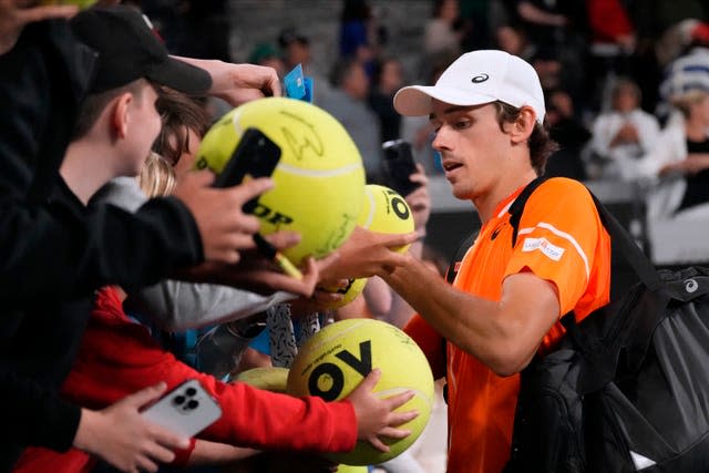 Alex De Minaur signs autographs