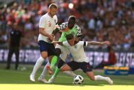 <p>Kieran Tripper under pressure from Nigeria’s Victor Moses, while Eric Dier (left) looks on </p>