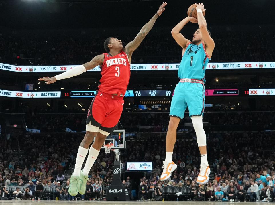 Phoenix Suns guard Devin Booker (1) shoots over Houston Rockets guard Kevin Porter Jr. (3) during the second half at Footprint Center on Dec. 2, 2022.