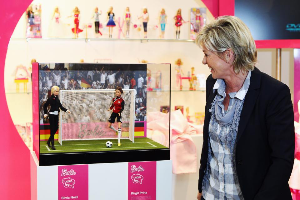 Silvia Neid, head coach of the German national women's football team, poses with two 'One Of A Kind Barbie' dolls representing herself and German striker Birgit Prinz at the Mattel stand during the International Toy Fair Nuernberg on February 3, 2011 in Nuremberg, Germany. 