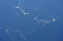 In this aerial photo taken from a maritime patrol aircraft of the Indonesian 800 Air Squadron of the 2nd Air Wing of Naval Aviation Center (PUSPENERBAL), oil slicks are seen in the area where the search operation for the submarine KRI Nanggala that went missing while participating in a training exercise on Wednesday is conducted in the waters off Bali Island, Indonesia, Thursday, April 22, 2021. Indonesia's navy ships on Thursday were intensely searching for the submarine that likely fell too deep to retrieve, making survival chances for all the crew on board slim. Authorities said oxygen in the submarine would run out by early Saturday. (AP Photo/Eric Ireng)