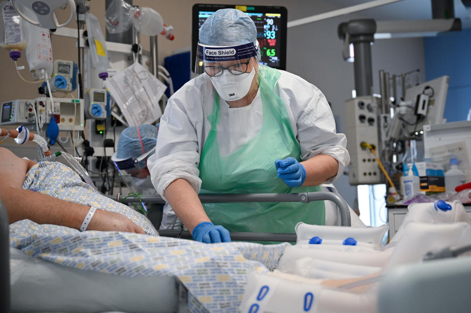 AIRDRIE, SCOTLAND - FEBRUARY 05: A member of staff at University Hospital Monklands attends to a Covid-positive patient on the ICU ward on February 5, 2021 in Airdrie, Scotland. The numbers of patients with Coronavirus at Lanarkshire hospitals hit record levels during Scotland's second wave of the pandemic with ICU staff members left feeling ‘physically and emotionally drained’. Patients admitted to Monklands ICU are much younger during this second wave, many with no underlying health conditions, which differ from the first wave where patients were more likely to be elderly and often ill before they contracted the virus. Figures published by Public Health Scotland on February 5 showed that 61 more Covid-positive patients who tested positive have died bringing the total to 6,383 and the total confirming as positive has risen by 895 to 184,313.  (Photo by Jeff J Mitchell/Getty Images)