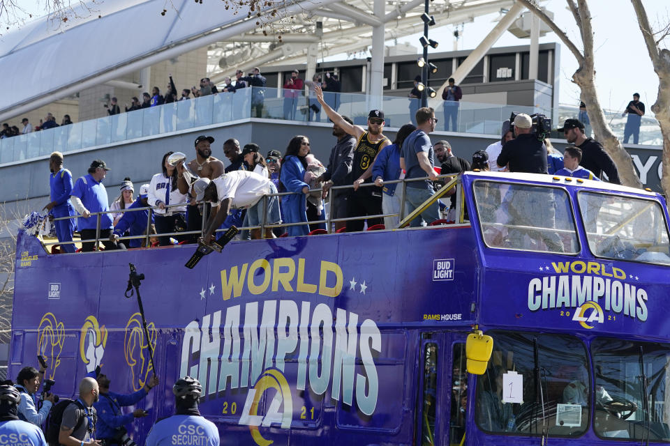 Los Angeles Rams wide receiver Cooper Kupp waves as he rides on a bus during the team's victory parade in Los Angeles, Wednesday, Feb. 16, 2022, following their win Sunday over the Cincinnati Bengals in the NFL Super Bowl 56 football game. (AP Photo/Marcio Jose Sanchez)