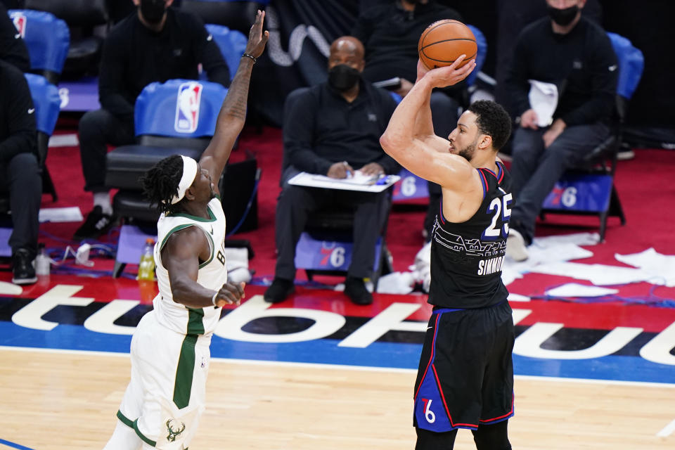 Philadelphia 76ers' Ben Simmons, right, goes up for a three-point shot against Milwaukee Bucks' Jrue Holiday during overtime in an NBA basketball game, Wednesday, March 17, 2021, in Philadelphia. (AP Photo/Matt Slocum)