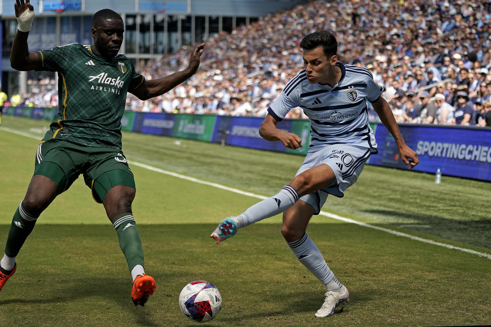 Sporting Kansas City forward Dániel Sallói (20) kicks the ball away from Portland Timbers defender Larrys Mabiala (33) during the second half of an MLS soccer match Sunday, May 28, 2023, in Kansas City, Kan. Sporting Kansas City won 4-1. (AP Photo/Charlie Riedel)