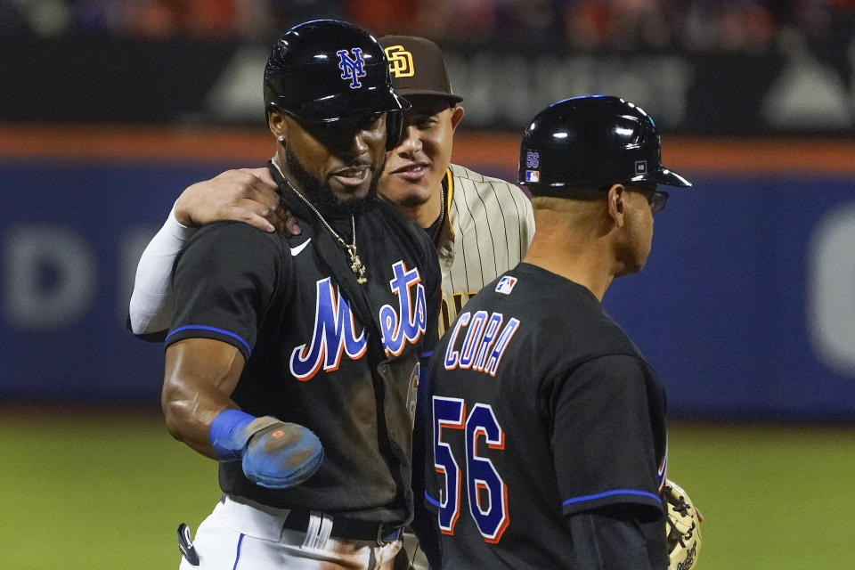 New York Mets right fielder Starling Marte (6) jokes with San Diego Padres third baseman Manny Machado (13) after stealing third base during the second inning of Game 1 of a National League wild-card baseball playoff series, Friday, Oct. 7, 2022, in New York. (AP Photo/John Minchillo)