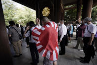 One of visitors carries a rising sun flag as he enters Yasukuni Shrine Saturday, Aug. 15, 2020, in Tokyo. Japan marked the 75th anniversary of the end of World War II. (AP Photo/Eugene Hoshiko)