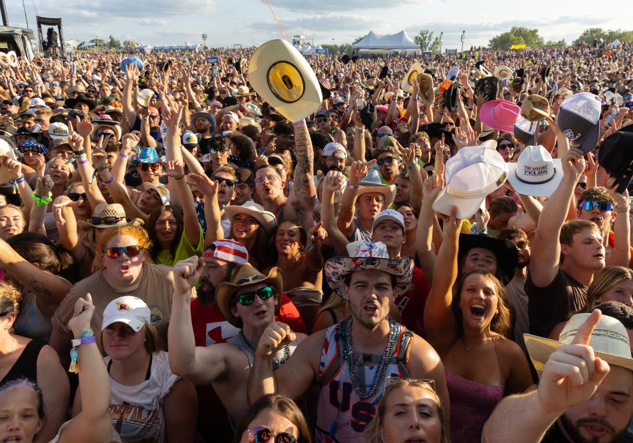 Fans cheer on the music Friday on the first day of Faster Horses.  The three-day country music and camping festival at the Michigan International Speedway in Brooklyn draws tens of thousands of music lovers.