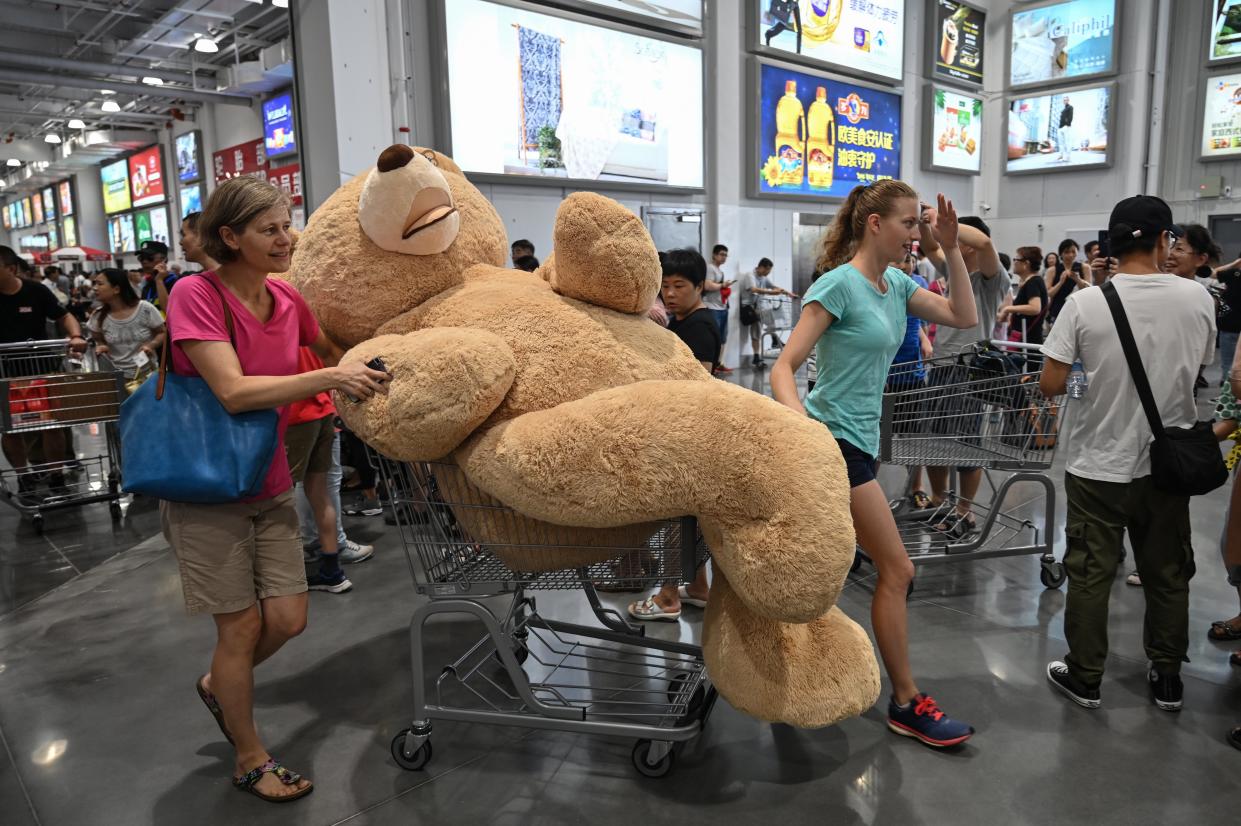 A woman pushes a trolley with a teddy bear at the first Costco outlet in China.