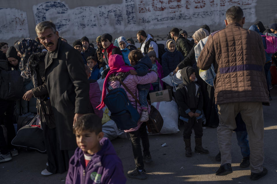 Syrians stand in a queue as they wait to return to their country from the Turkish crossing point of Cilvegozu, in Reyhanli, southeastern Turkey, Saturday, Feb. 18, 2023. A 7.8 magnitude earthquake with its epicenter in Turkey's southeastern Kharamanmaras province struck in the early hours of Feb. 6, followed by multiple aftershocks, including a major one magnitude 7.5 nine hours after the first tremor. (AP Photo/Bernat Armangue)