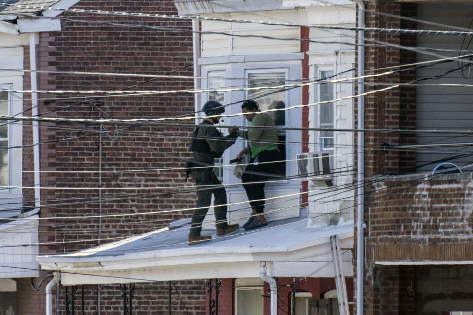 Police remove people from a home in Trenton New Jersey, on March 16, 2024, after reports of a gunman, who is suspected of a shooting spree in Pennsylvania, was barricaded in a house on the block.  / Credit: JOE LAMBERTI/AFP via Getty Images