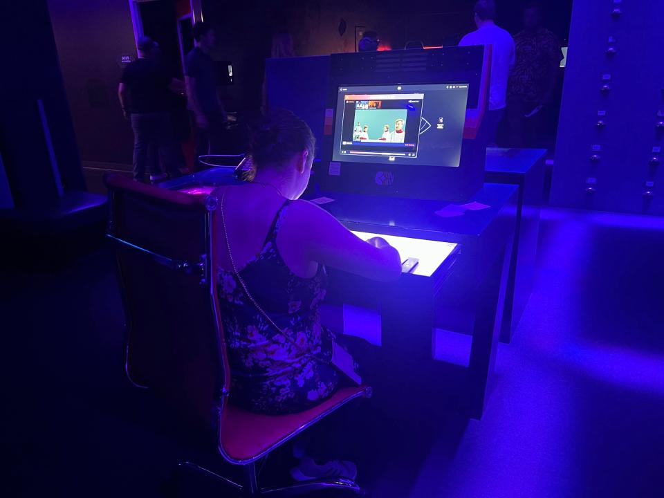 A woman working on the computer in the blue-lit office.