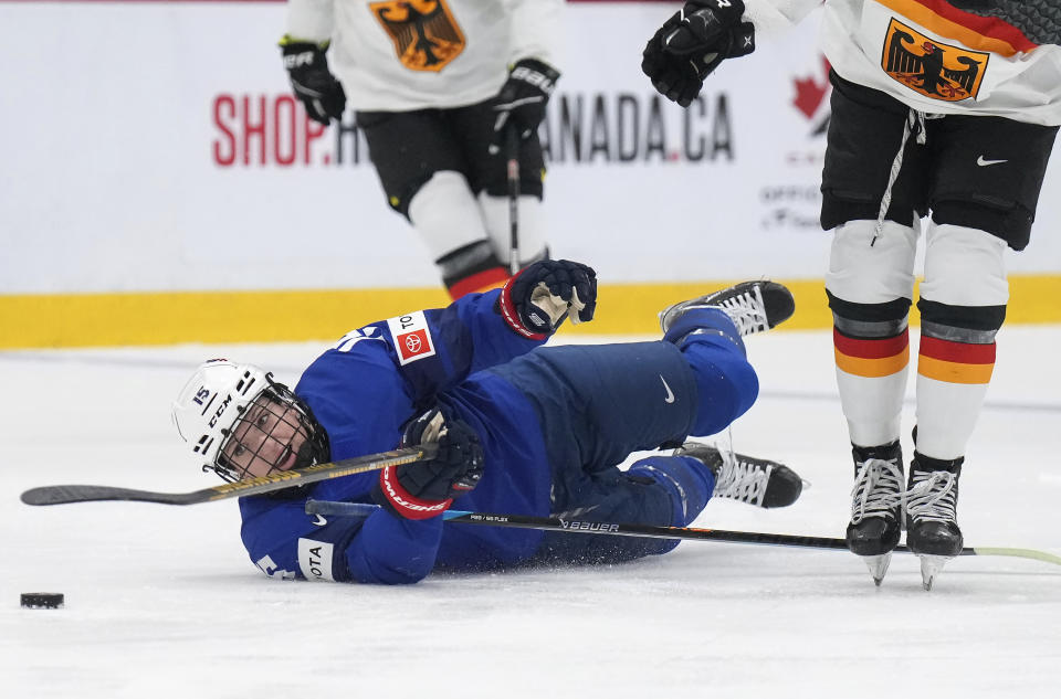 USA defender Savannah Harmon (15) is tripped up by Germany forward Celina Haider, right, during the second period of a quarterfinal match at the Women's World Hockey Championships in Brampton, Ontario, Thursday, April 13, 2023. (Nathan Denette/The Canadian Press via AP)